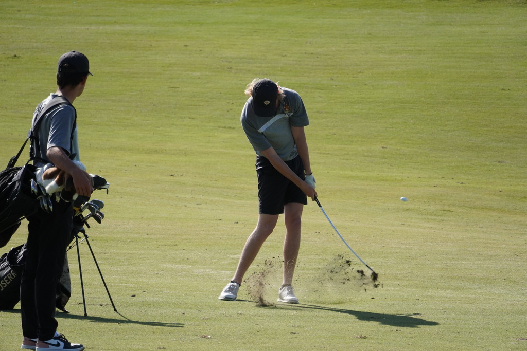 Kal hitting his second shot into the green on hole 1 with the encouragement of his teammate Jack.
