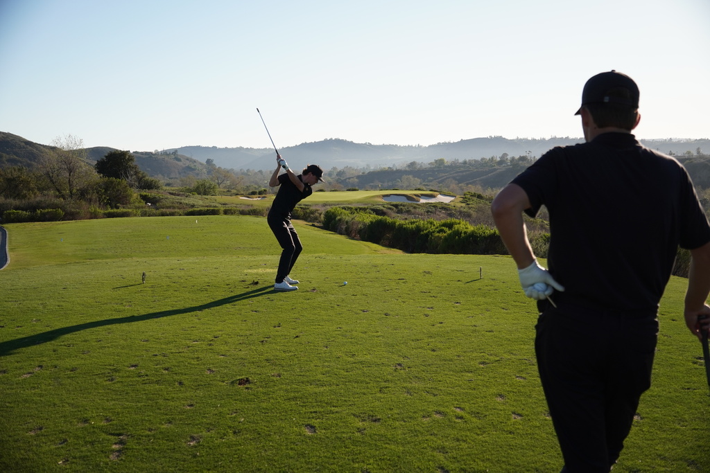 Adam on the tee box of hole 8 while teammate Finn watches.