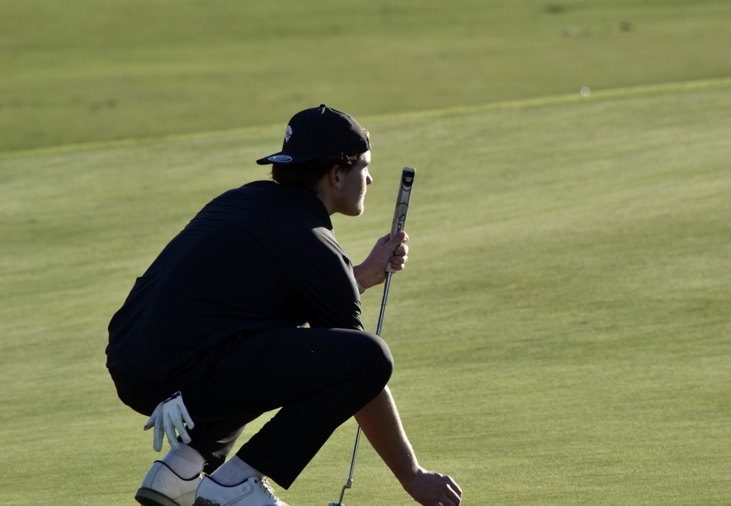 Louie Curran, the medalist with the low score, is lining up his next shot.