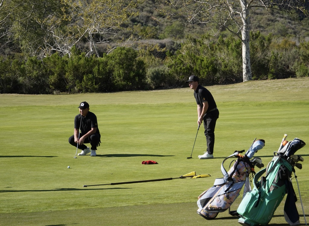 Liam on the putting green of hole 1 lining up his putt for birdie.  Liam made the putt to start the round 1 under.