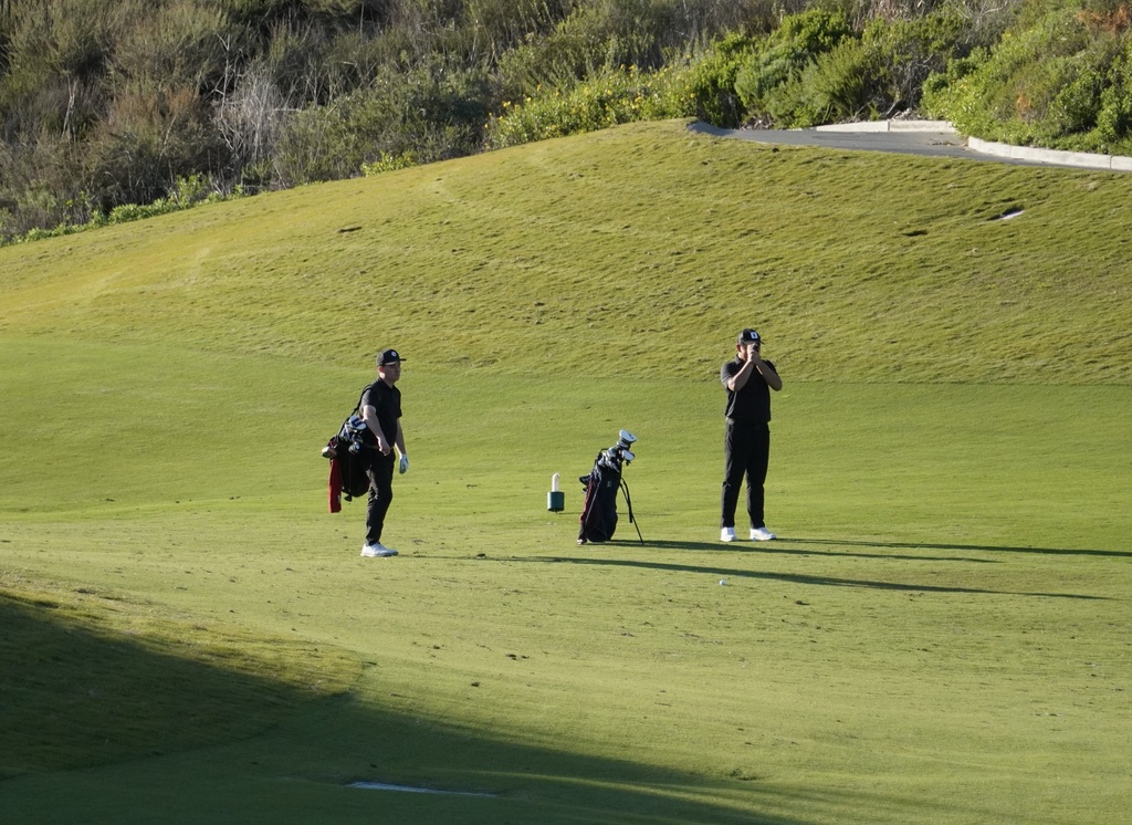 Liam and Lucas preparing for their approach shot into the green of hole 6.
