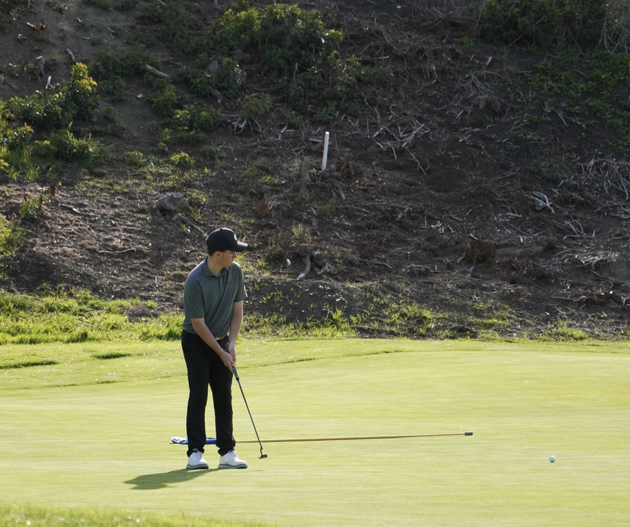 Liam putting for birdie on the green of hole 4.  He was able to make the birdie putt.