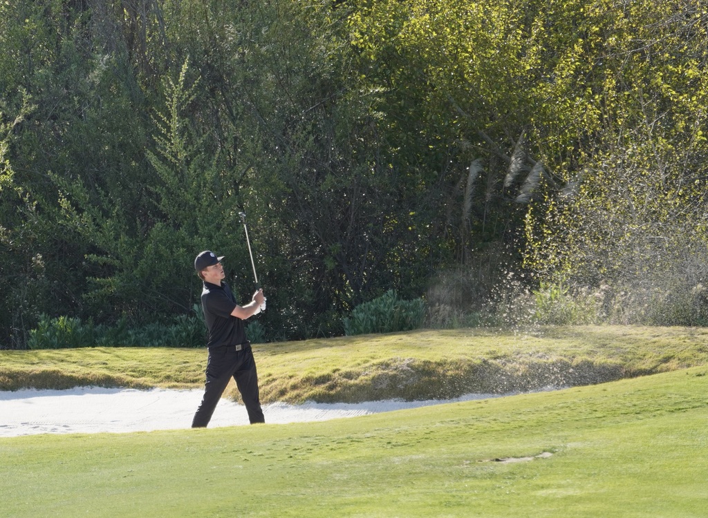 Finn hitting out of the sand onto the green of hole 3.  Finn was able to save par with his successful chip onto the green.