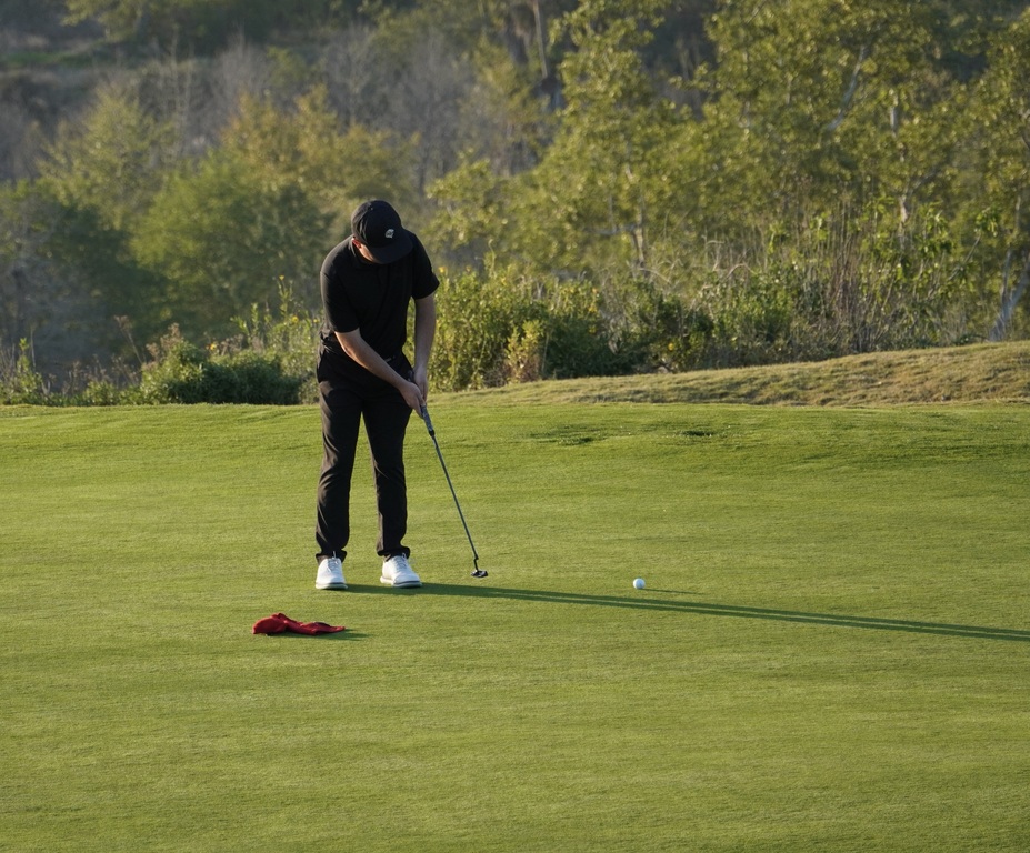 Liam McNamara on the putting green of hole 7 putting for eagle.  Liam successfully made the eagle putt.
