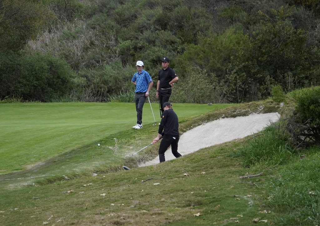 Gavin getting out of the bunker next to the green of hole 6.