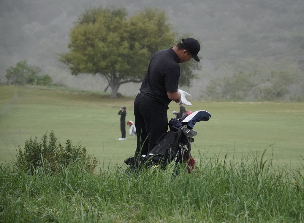 Lucas finding his ball in the hazard of hole 7.