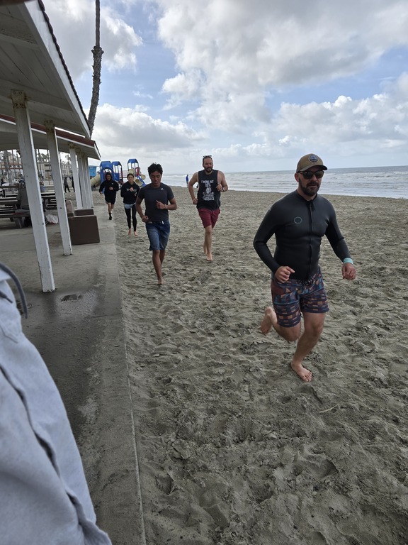 Coaches and swimmers 🏊‍♂️ during dry land training at the pier.  Wooo boi, was it windy!!!