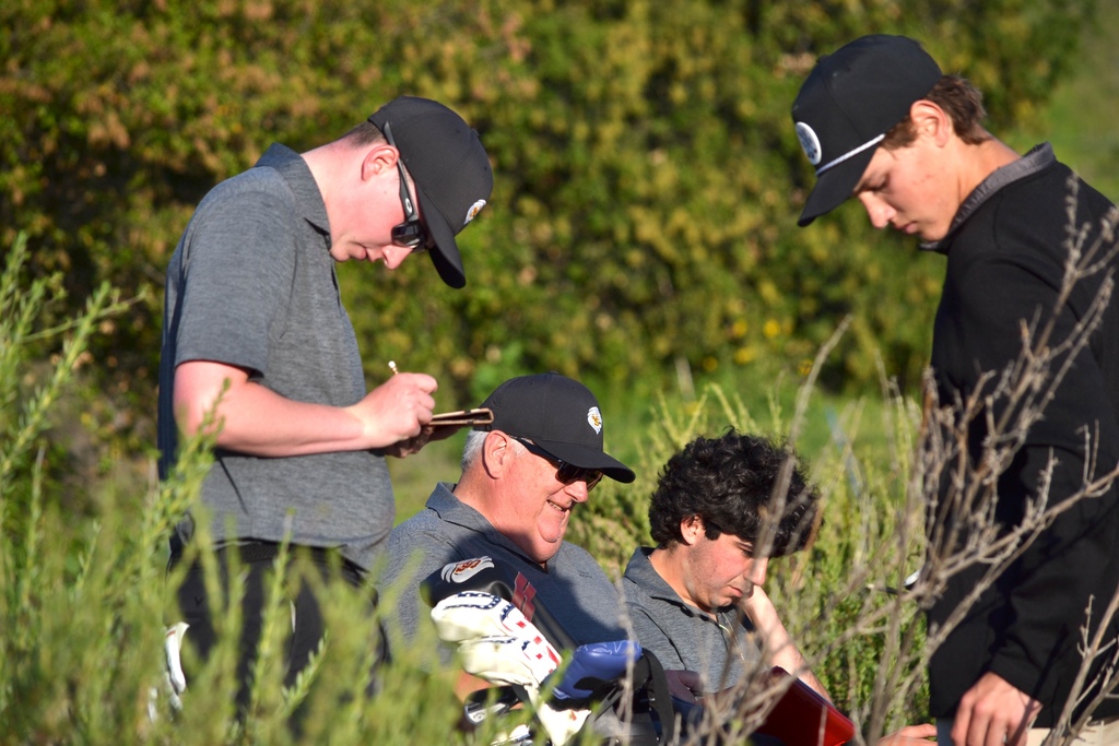 Colton and Gavin adding up their scores with Coach Tom