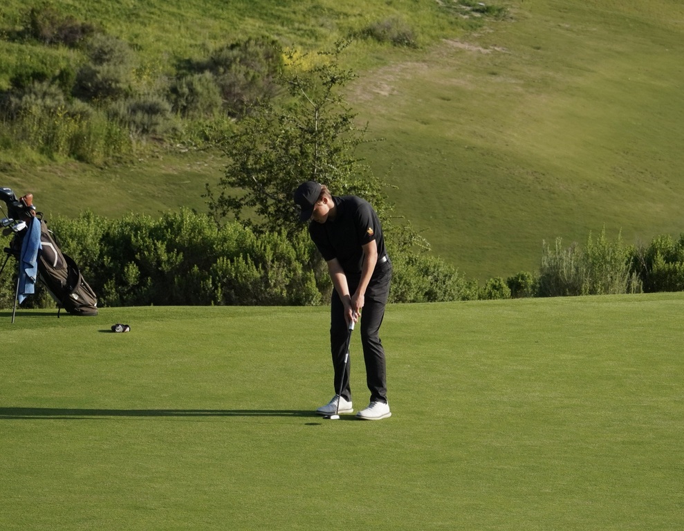 Finn on the putting green of hole 9 finishing his round.  This is Finn's final putt for JSerra at our home course.
