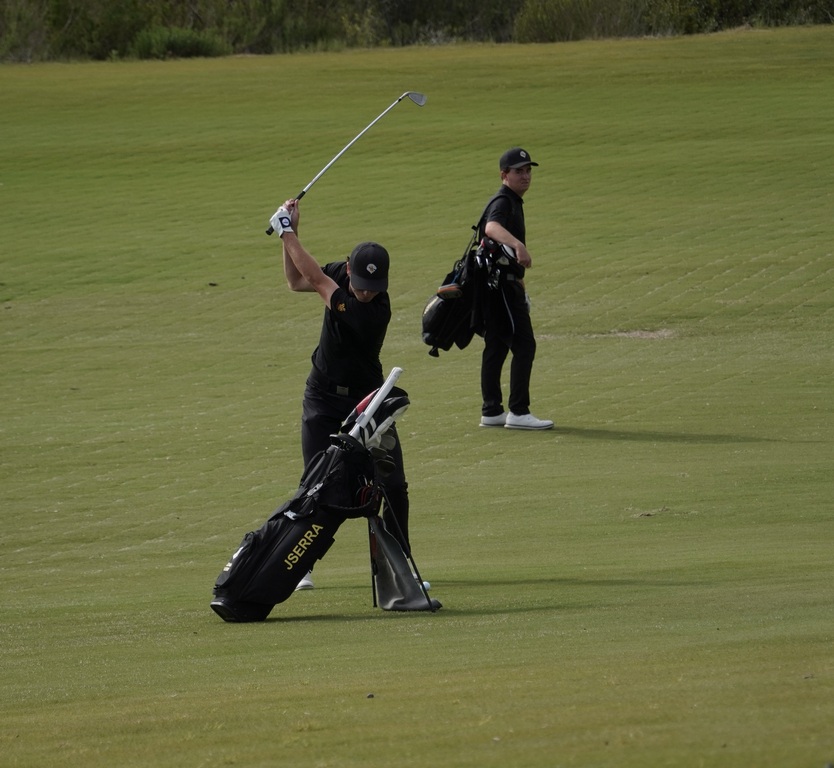 Adam Rusin with his approach shot into the green of hole 3 while Liam watches.