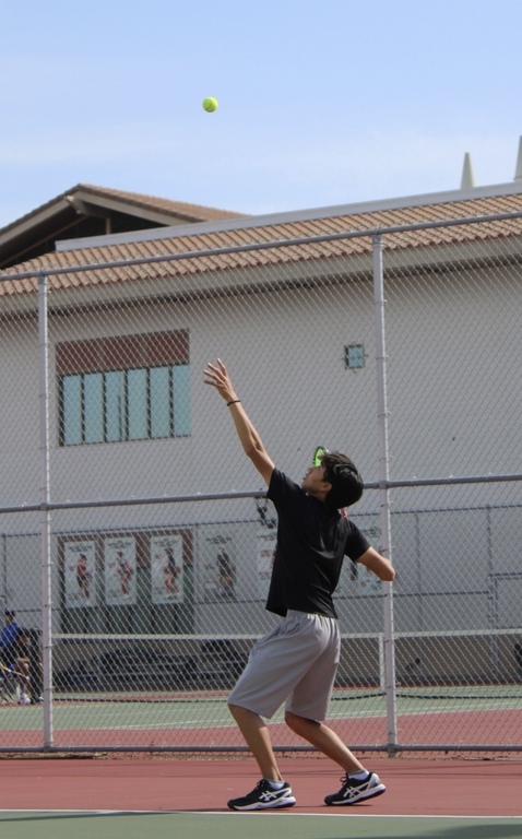 MUN Student Remy Vo Serving at a Tennis Match