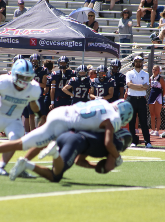 #55 for the Varsity Trojans Luke Emrich smothers the ball carrier and brings him down for the tackle