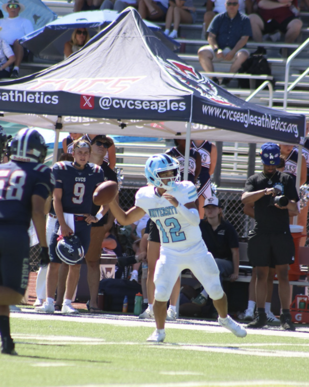 QB #12 Dylan Elmer steps in to fire the football for the Varsity Trojans