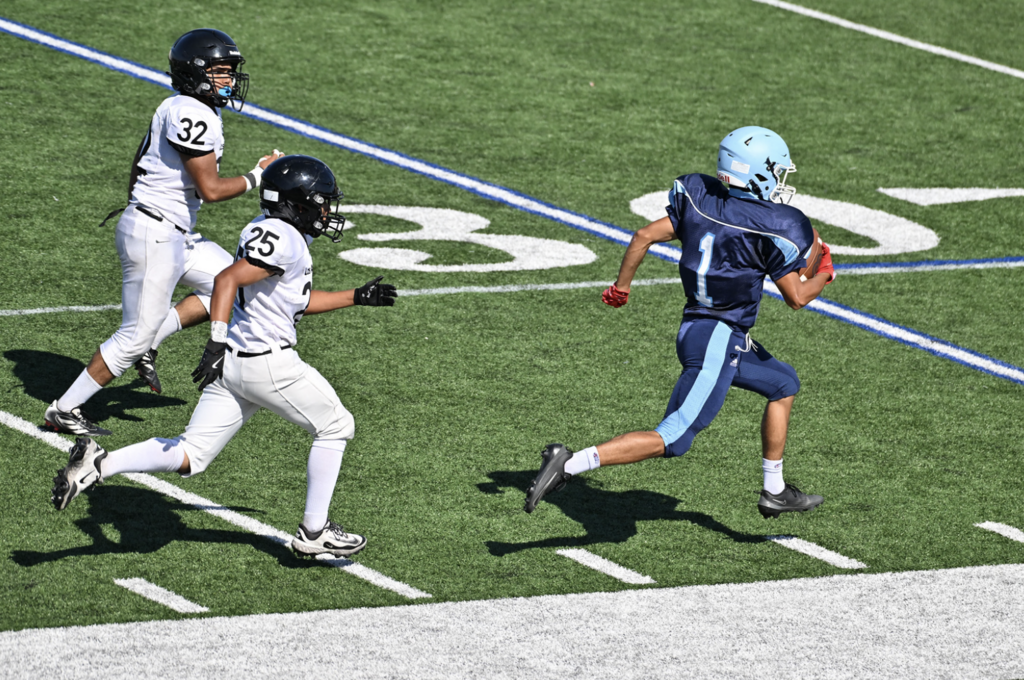 Frosh Muqtader Ahmadi races down the sideline for the Trojans