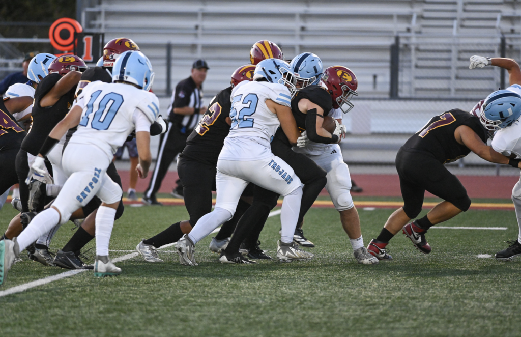 #52 Captain Adham Osman gets in on the tackle for University.