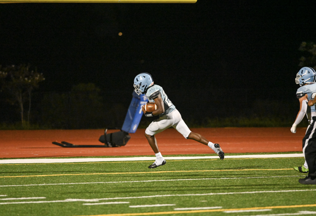 #20 Deandre Miller with a scoop and score for the defense while scoring his first Varsity TD sealing the 34-7 win over John Glenn.  For more great photos, visit:  https://unifootballboosters.smugmug.com/20252026-UNI-TROJANS-FOOTBALL/Varsity