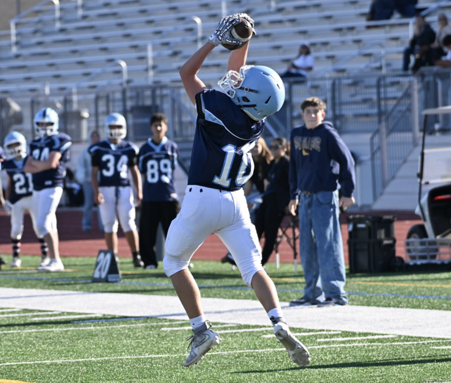 #10 Chase Tobin reaches up high to catch the football for University.  For more photos visit: https://unifootballboosters.smugmug.com/20252026-UNI-TROJANS-FOOTBALL/2025FROSH