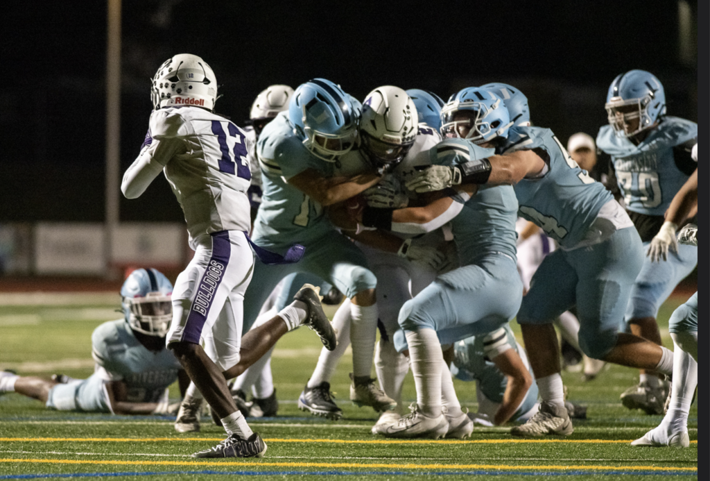 Varsity Trojans gang up to get a team tackle against Portola ball carrier.  For more great photos of this game and season visit: https://unifootballboosters.smugmug.com/20252026-UNI-TROJANS-FOOTBALL/Varsity