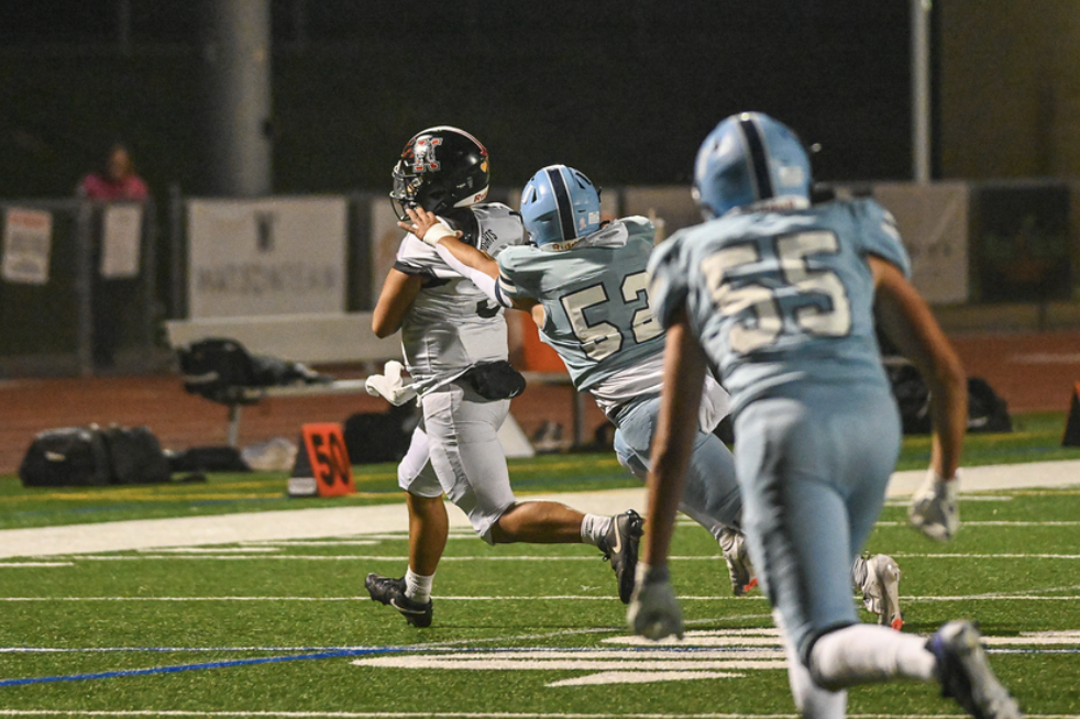 Senior #52 was a stand out player all year long for the Trojans, here chasing down the Katella running back for a loss, one of Adham's 45 tackles for the season. For more great photos of this game and season visit: https://unifootballboosters.smugmug.com/