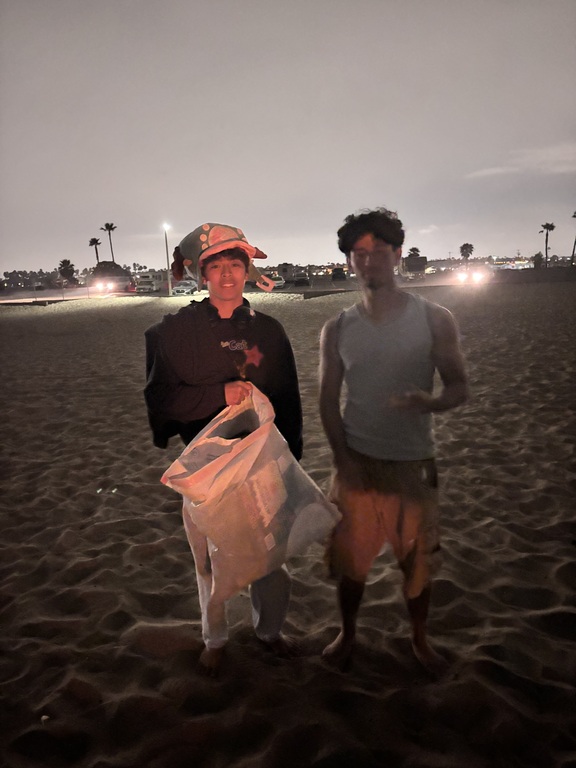 Two young chaps cleaning the beach for capstone project