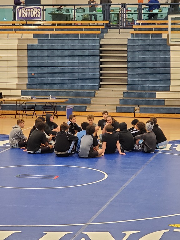 Jv wrestling circles up during break